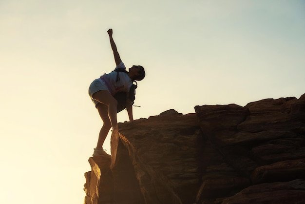 Foto vista ad angolo basso di una donna in piedi su una roccia contro il cielo