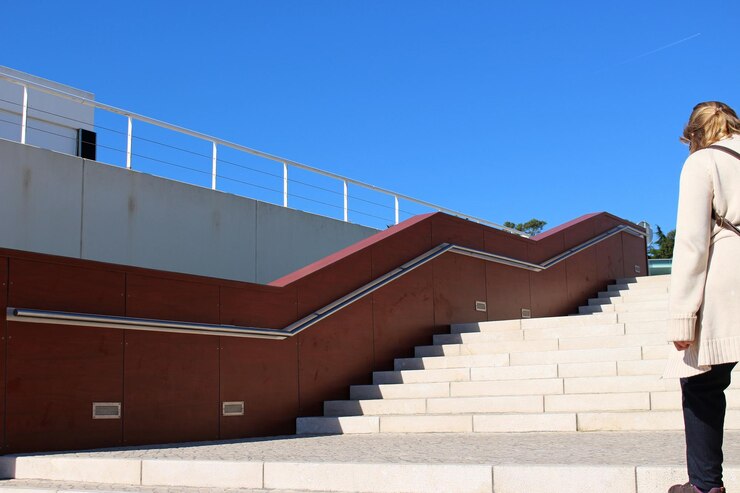 Photo low angle view of woman standing on stairs against clear sky