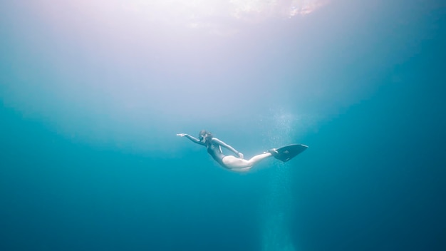 Foto vista a bassa angolazione di una donna che nuota sott'acqua