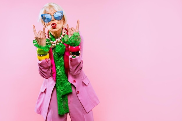 Photo low angle view of woman wearing sunglasses against pink background