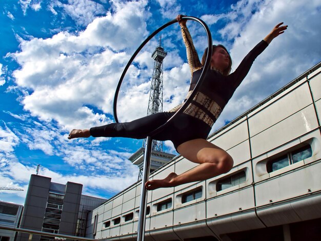 Foto vista ad angolo basso di una donna con le braccia alzate contro il cielo