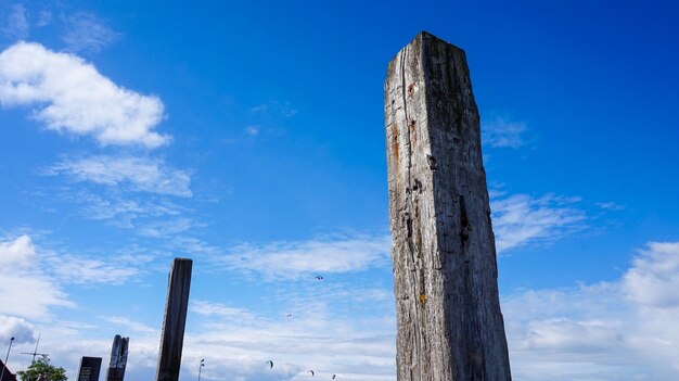 Low angle view of wooden post against sky