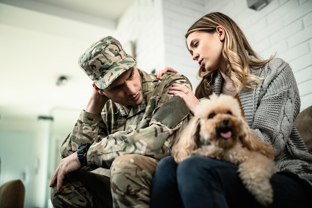 Low angle view of worried woman talking to her military husband who is about to leave for deployment