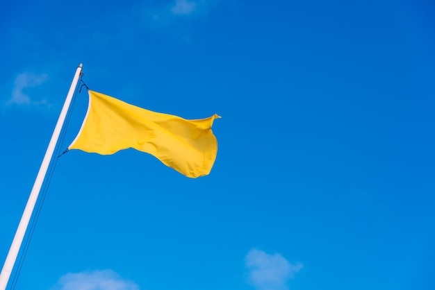 Photo low angle view of yellow flag against blue sky