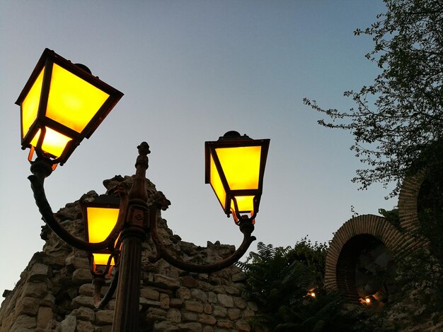 Low angle view of yellow street light against sky