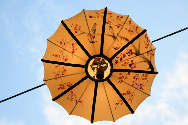 Photo low angle view of yellow umbrella hanging on cable against sky