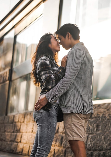 Foto vista a basso angolo di una giovane coppia che ha una storia d'amore in piedi all'aperto