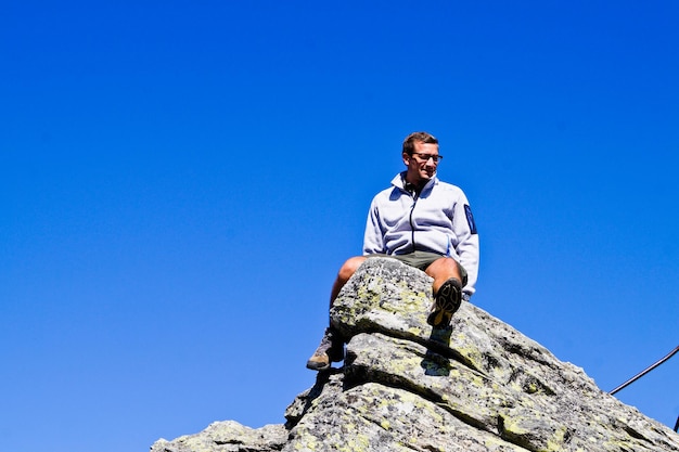 Photo low angle view of young man against rock