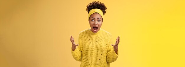 Low angle view of young man against yellow background