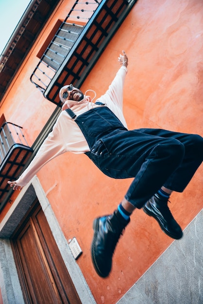 Photo low angle view of young man jumping against wall