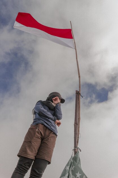 Photo low angle view of young man standing against sky