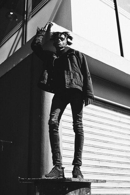 Photo low angle view of young man standing against wall