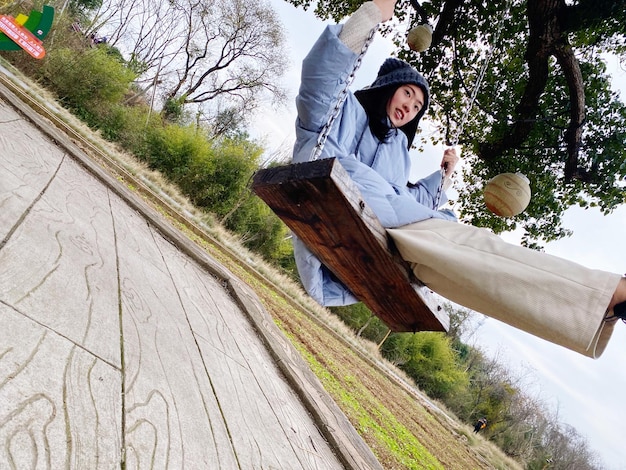 Photo low angle view of young woman sitting on boardwalk