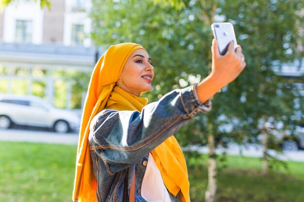 Foto vista a basso angolo di una giovane donna che usa un telefono cellulare