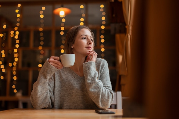 Donna di angolo basso con caffè