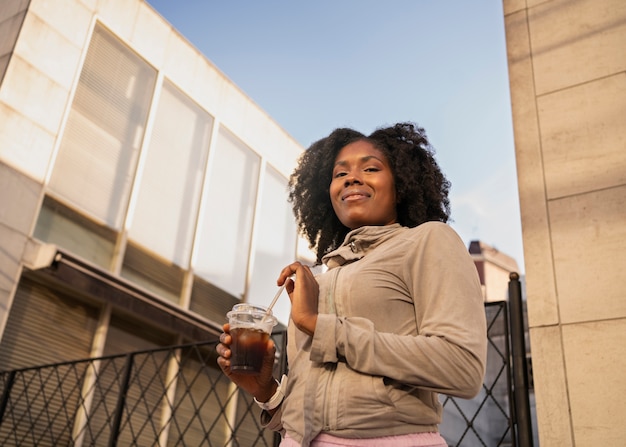 Foto donna di angolo basso con caffè freddo