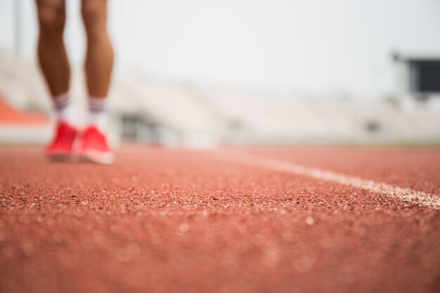 Sezione bassa dell'atleta in piedi sulla pista sportiva