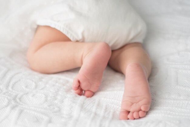 Photo low section of baby lying on bed