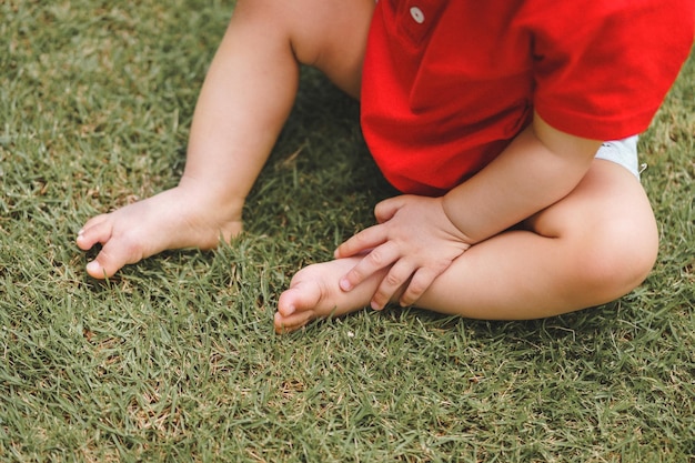 Low section of baby sitting on field