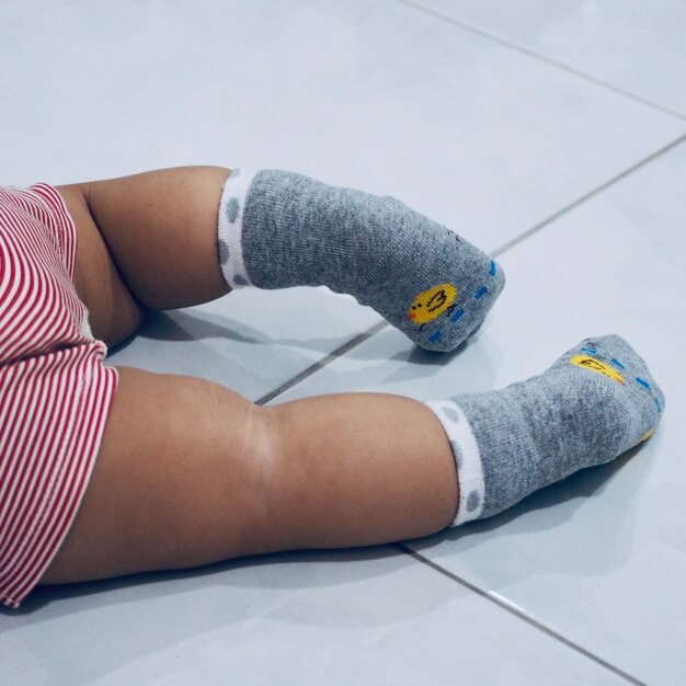 Photo low section of baby on tiled floor