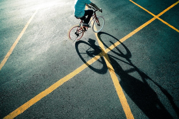 Foto sezione bassa di un ragazzo in bicicletta sulla strada