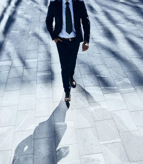 Low section of businessman walking on footpath