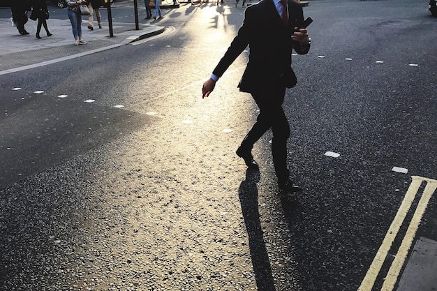 low section of businessman walking on road