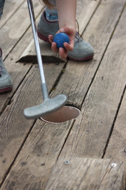 Foto sezione bassa di un bambino che gioca a golf sul lungomare