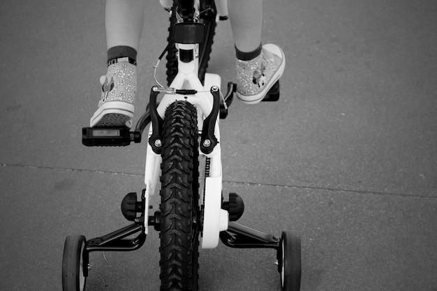 Foto sezione inferiore di un bambino in bicicletta su strada