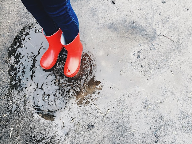 Photo low section of child standing on puddle