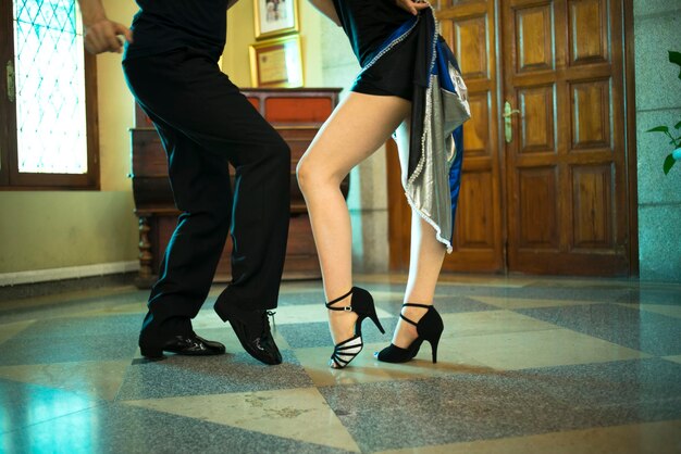 Low section of couple dancing on tiled floor