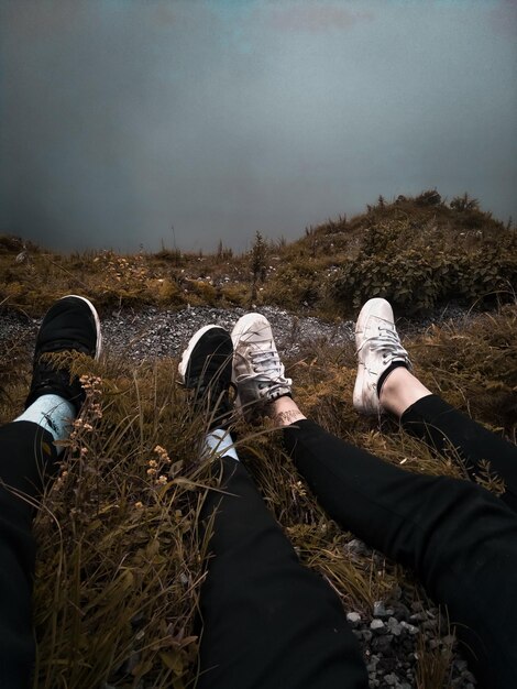 Photo low section of couple on field against sky