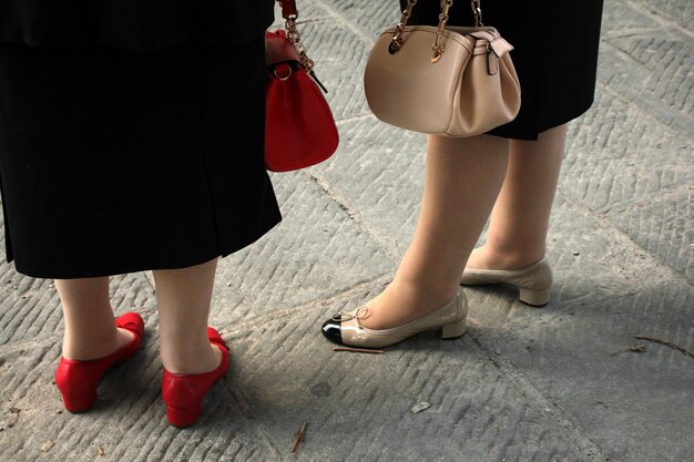 Low section of friends standing on footpath