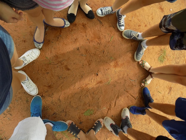 Photo low section of friends standing on sand