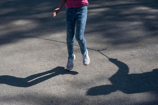 Foto sezione bassa di una ragazza che salta sulla strada