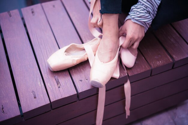 Low section of girl wearing ballet shoe