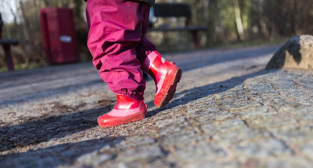 Foto sezione bassa di una ragazza che indossa scarpe rosse che cammina per strada