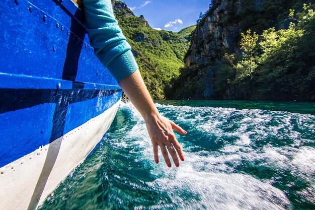 Foto sezione bassa di un uomo su una barca in mare contro il cielo