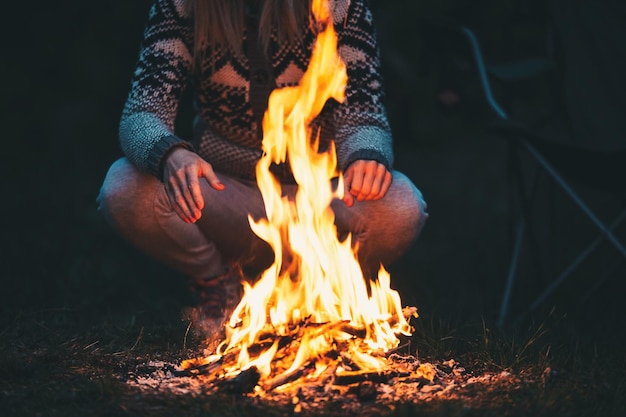 Photo low section of man crouching by campfire on field at night