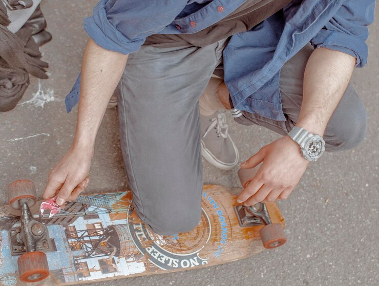 Photo low section of man crouching by skateboard