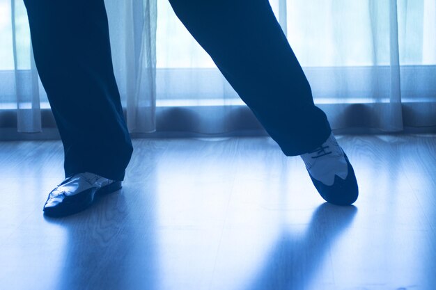 Low section of man dancing on parquet floor