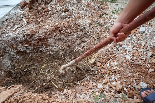 Foto sezione inferiore dell'uomo che scava il suolo con lo strumento di lavoro