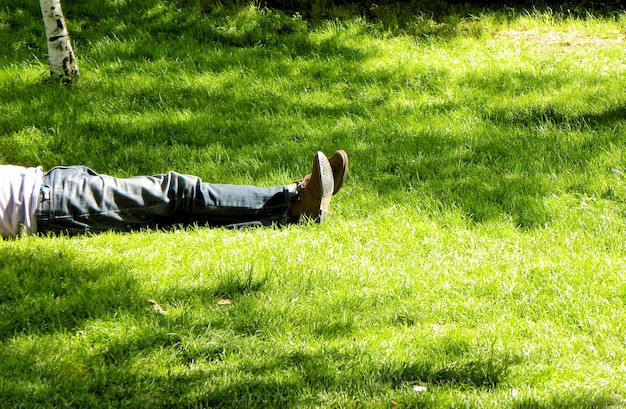 Foto sezione bassa di un uomo sdraiato sul campo erboso