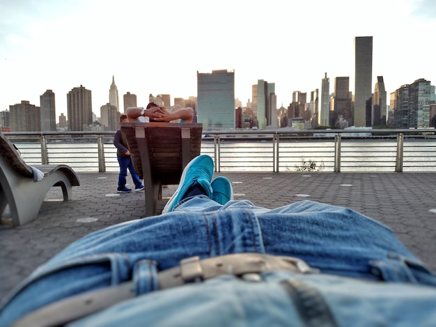 Foto sezione bassa di un uomo sdraiato sulla passeggiata al gantry plaza state park