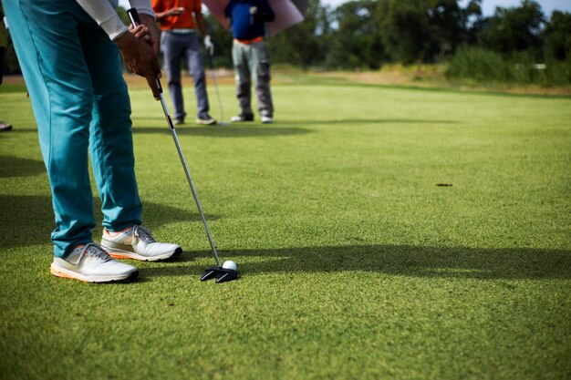 Foto sezione bassa di un uomo che gioca a golf sull'erba