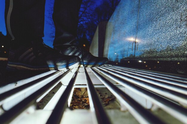 Foto sezione bassa dell'uomo sui binari della ferrovia di notte