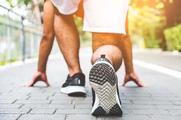 Photo low section of man ready to run on footpath in park