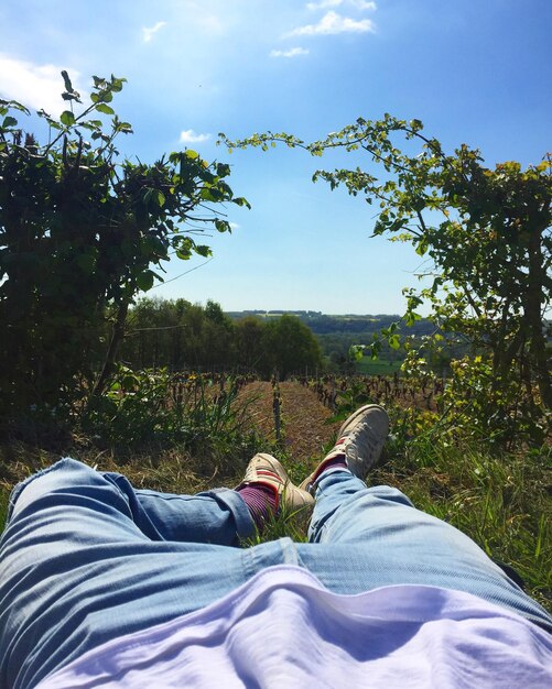 Photo low section of man relaxing against sky