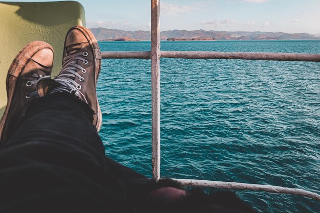 Photo low section of man relaxing by sea