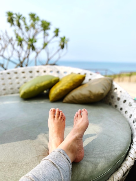 Photo low section of man relaxing in sea against sky